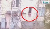 UZNEMIRUJUĆI VIDEO: Otmičar iz Sankt Peterburga maltretira dete na prozoru, steže ga za vrat i udara