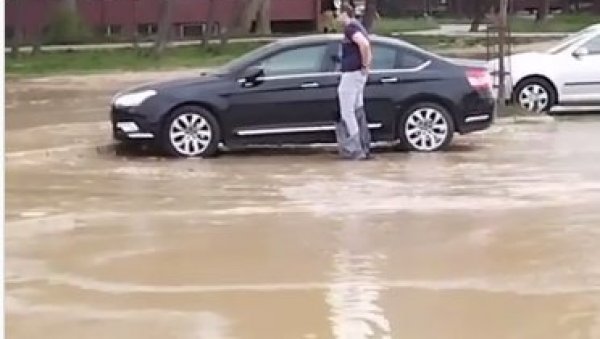 СНИМАК ПОТОПА НА НОВОМ БЕОГРАДУ: Вода куља на све стране, људи навлаче кесе на ноге да дођу до возила