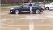 SNIMAK POTOPA NA NOVOM BEOGRADU: Voda kulja na sve strane, ljudi navlače kese na noge da dođu do vozila