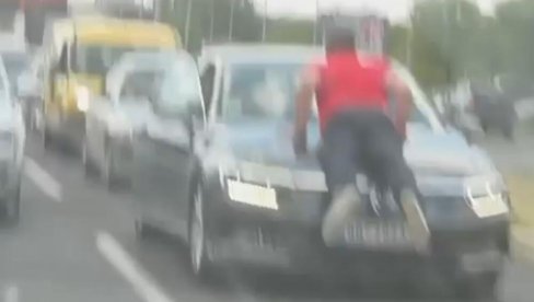 СНИМАК СА САЈМА ШОКИРАО СВЕ: Мушкарац се вози на хауби аутомобила (ВИДЕО)
