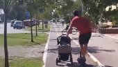 МОЗАК, ШТА ТО БЕШЕ? Снимак мушкарца из Новог Сада згрозио јавност - вози тротинет и гура бебу у колицима (ВИДЕО)