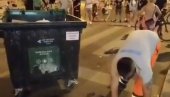 БАГРА БЛОКАДЕРА ГЛЕДА  И СМЕЈЕ МУ СЕ: Радник чистоће скупља просуто смеће из контејнера (ВИДЕО)
