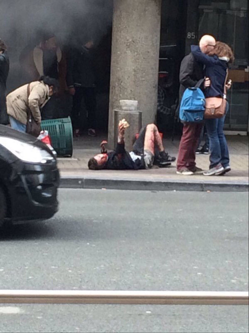 НАЈПОТРЕСНИЈА ФОТОГРАФИЈА ИЗ БРИСЕЛА: Преживели се грле поред крвавог човека који лежи и пружа им руку!  