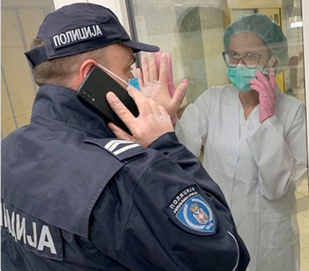 Слика која ће вам натерати сузе на очи: Дирљив сусрет медицинске сестре из Ургентног центра и њеног мужа полицајаца, причају телефоном, између њих стакло